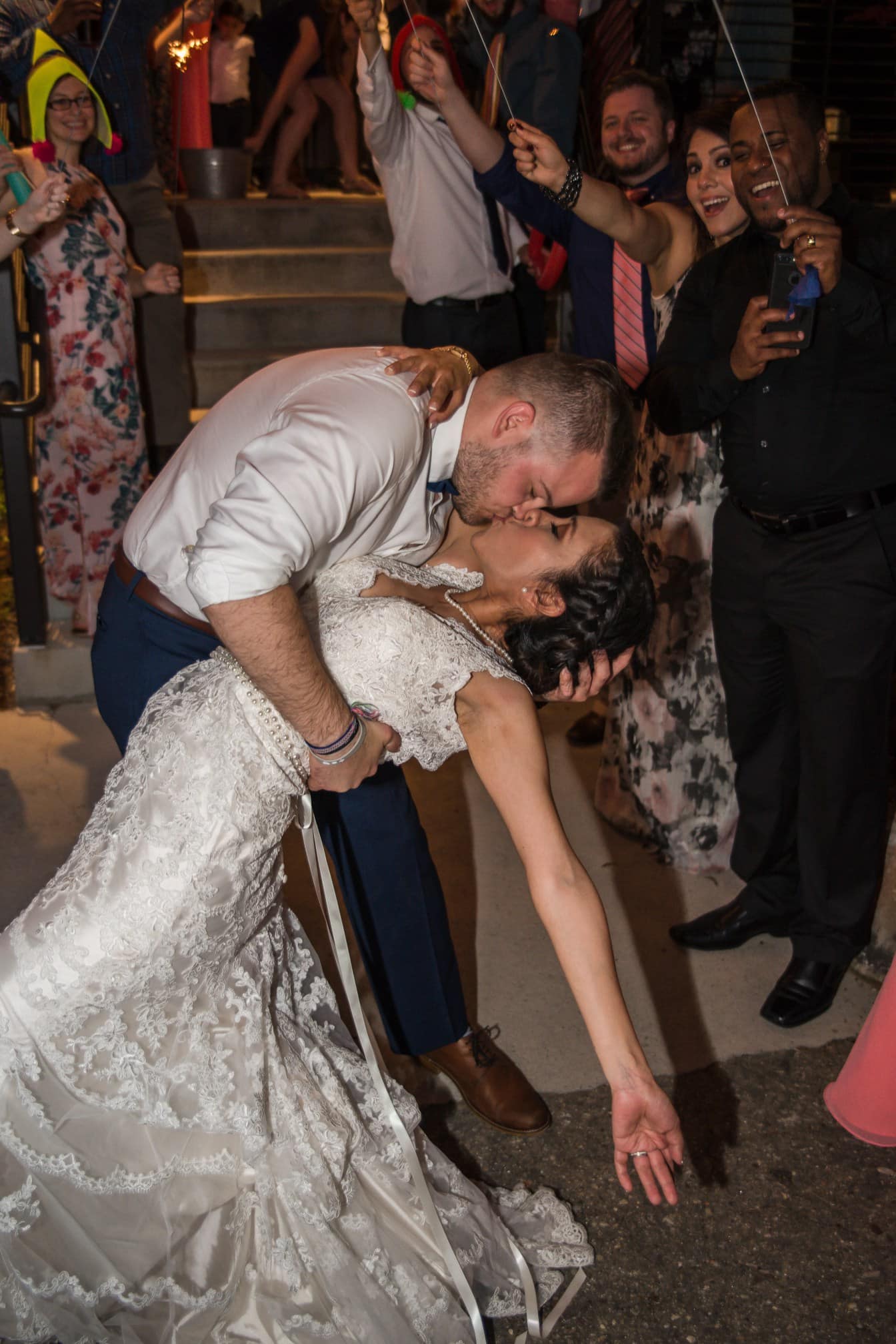 Sandra and Jacob kissing as their wedding guests celebrate at Highland Brewing