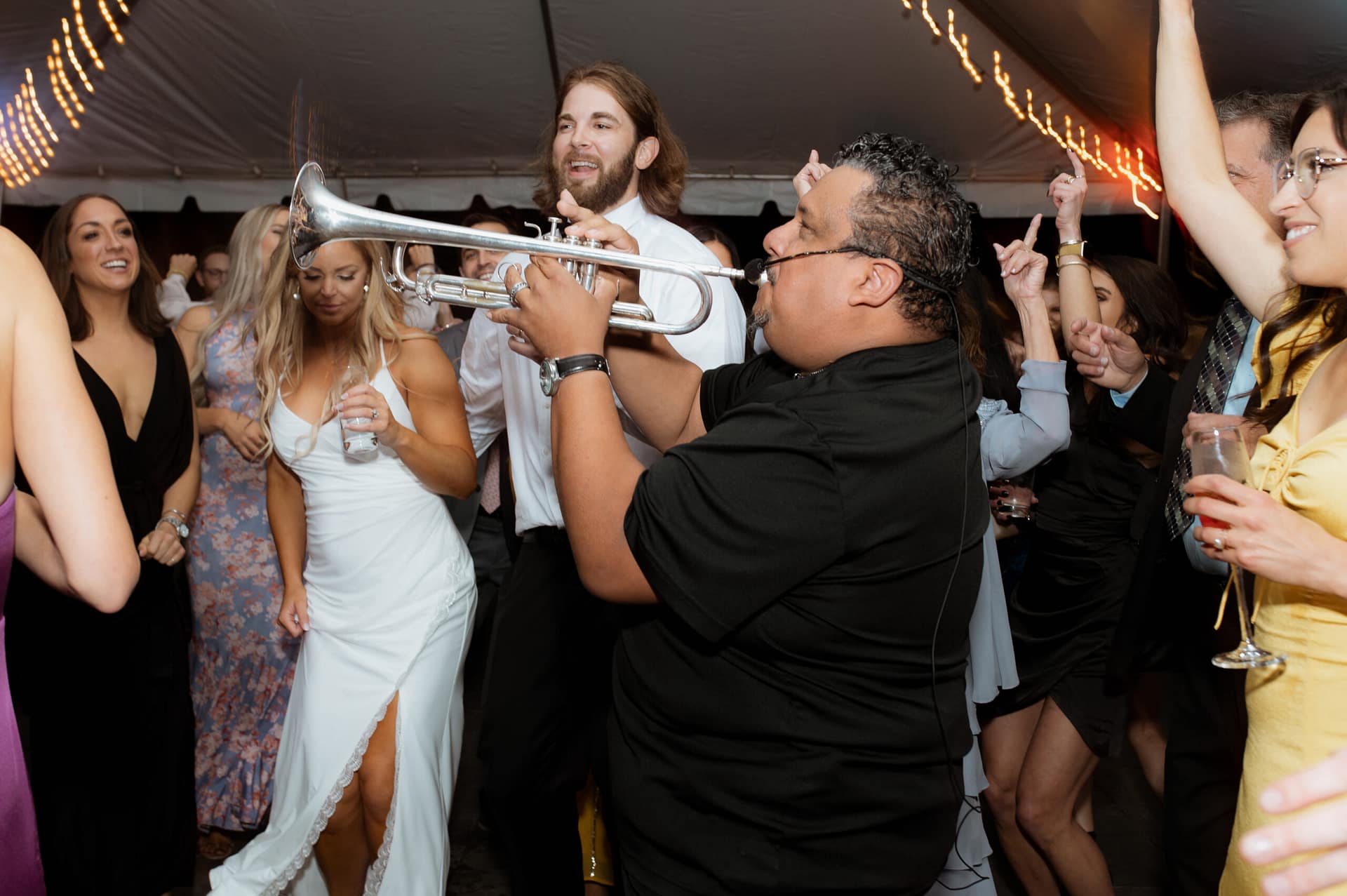 DJ P-LO performing live trumpet inside an event celebration